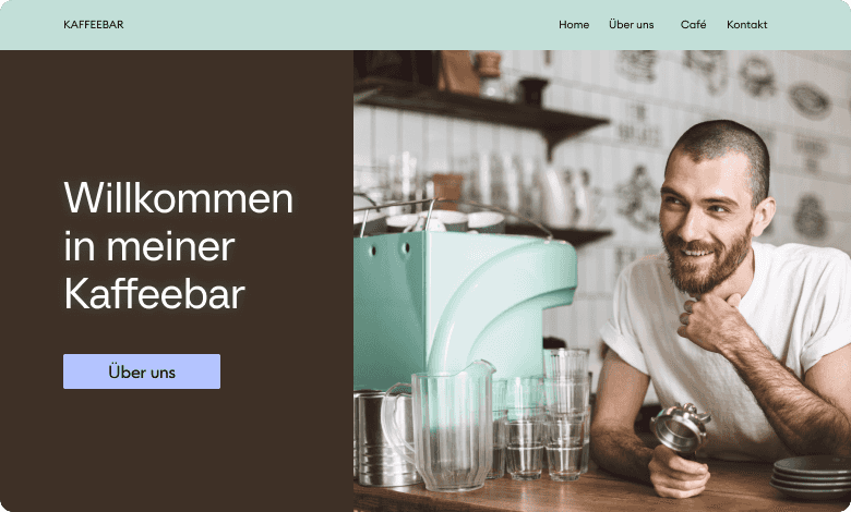 Barista lächelt neben einer mintgrünen Espressomaschine, mit Gläsern auf der Theke und cafébezogener Wandkunst im Hintergrund.