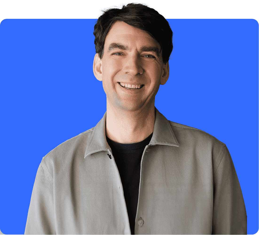 Matthias 'Matze' Henze, CEO and founder of Jimdo, wearing a brown flat cap and light blue shirt, smiling warmly at the camera, against a light purple background.